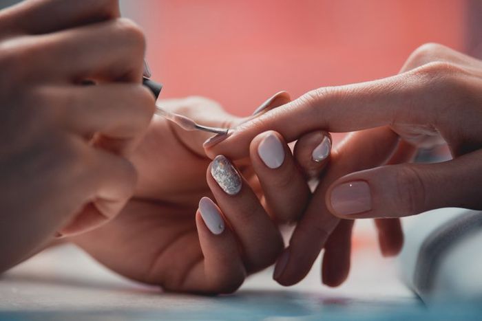 Woman master arm applying lacquer in salon