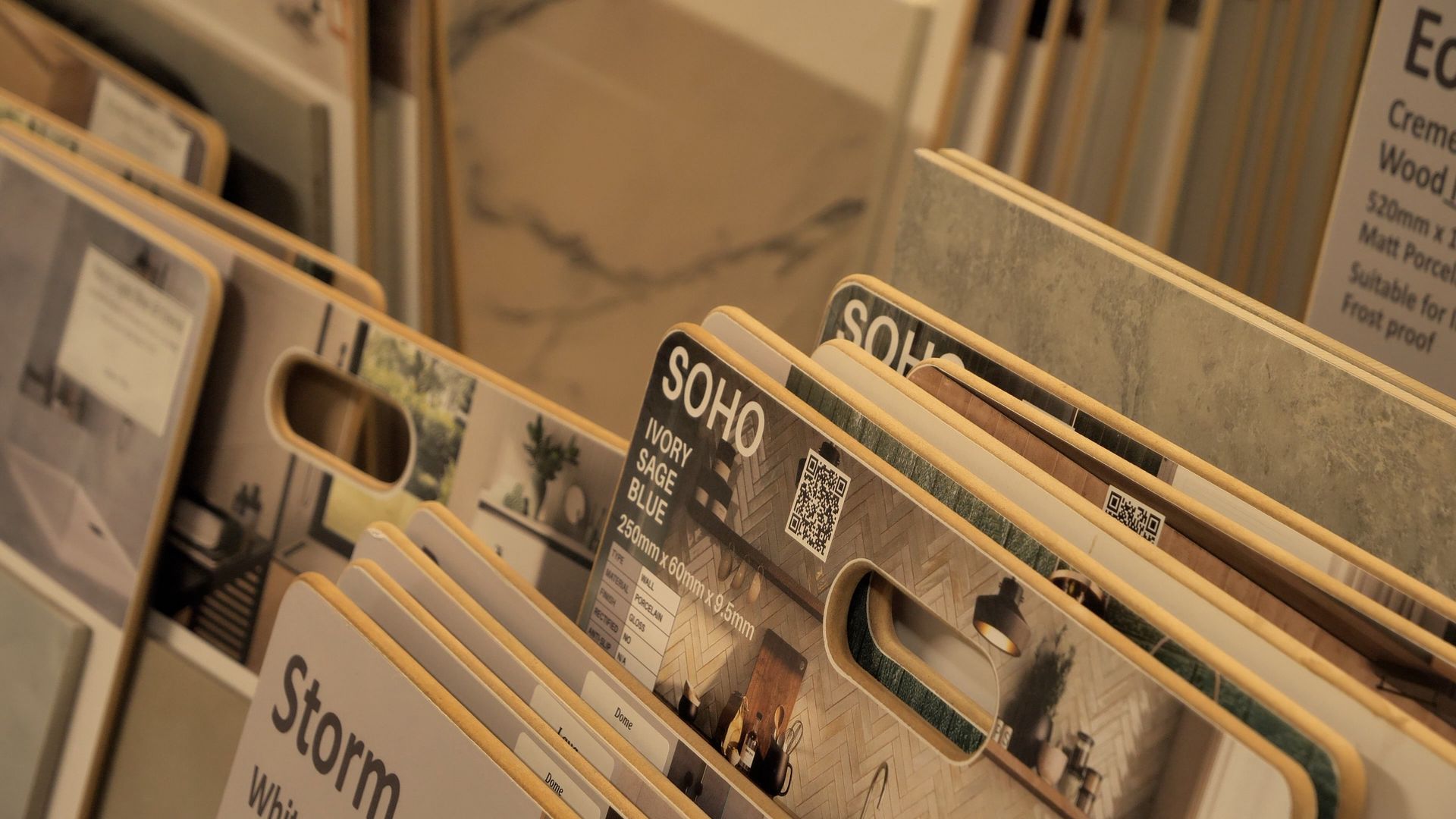 Tile samples arranged in a display rack, showcasing various patterns and textures.