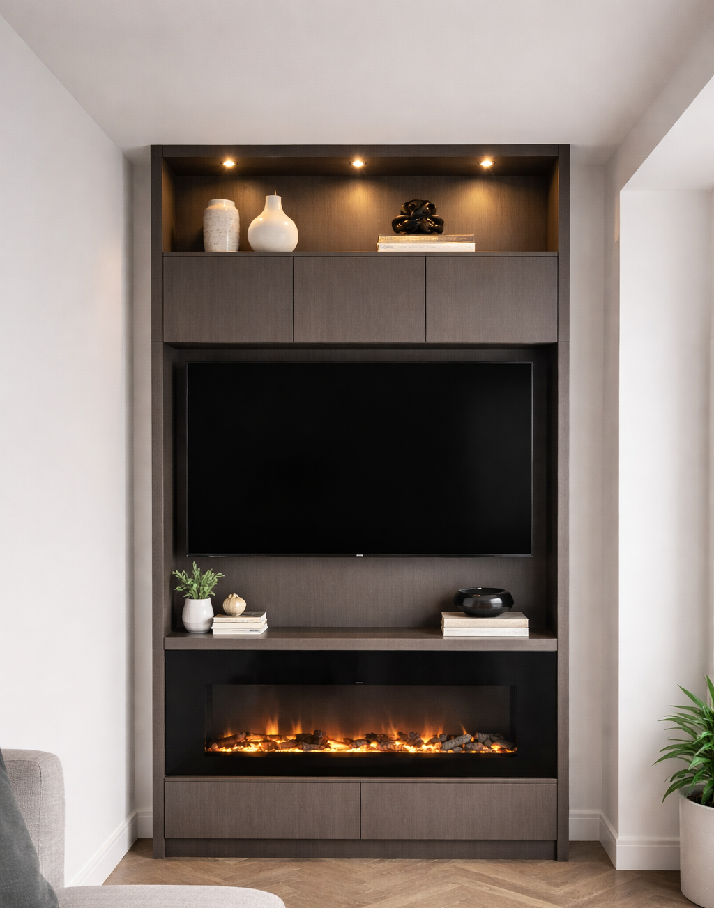 Built-in media center with a TV, electric fireplace, and shelves, lit by overhead lights.