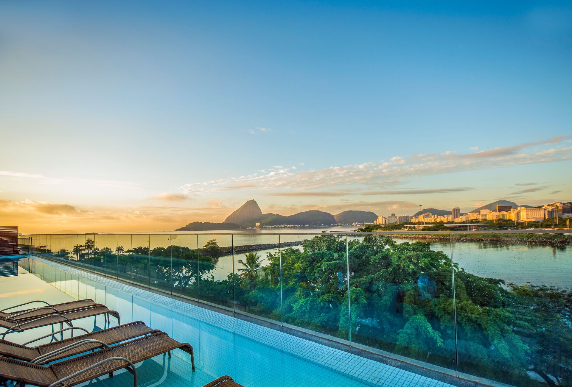 Há uma piscina no telhado de um prédio com vista para o oceano.