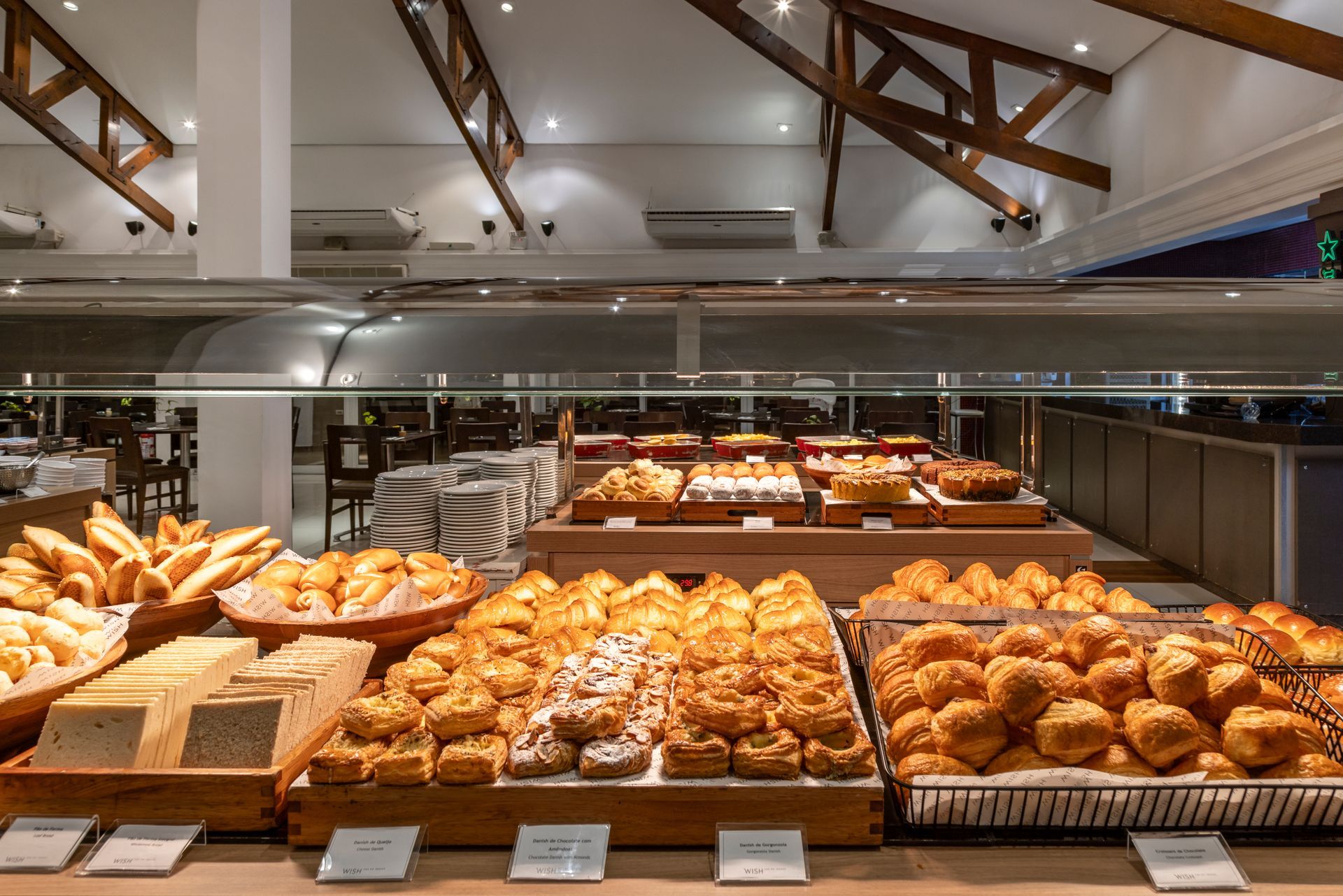 Um buffet repleto de pães e doces.