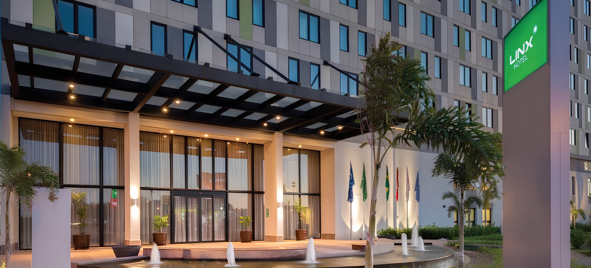 Hotel entrance with a fountain and a sign.