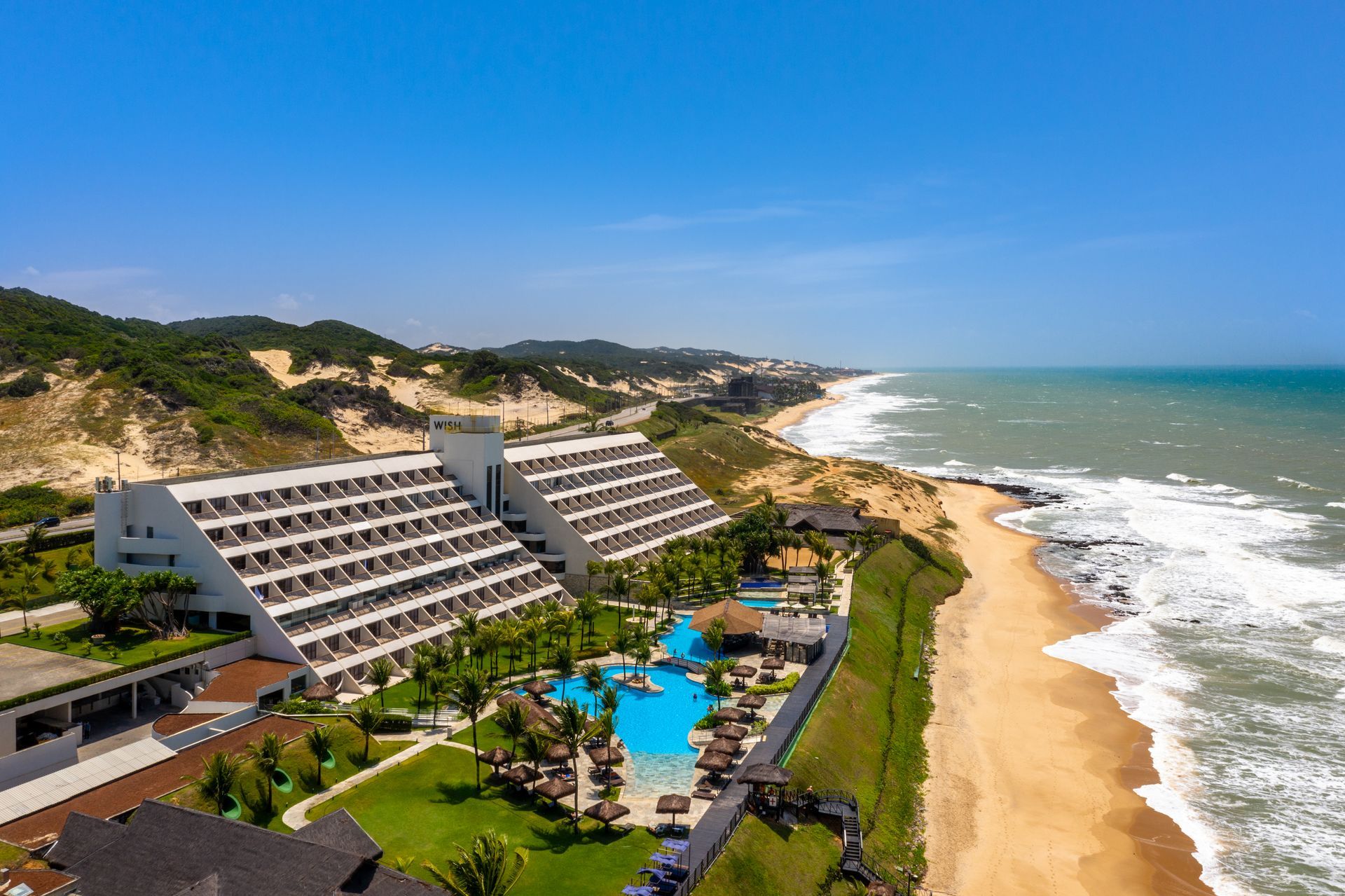 Uma vista aérea de um hotel em uma praia próxima ao oceano.