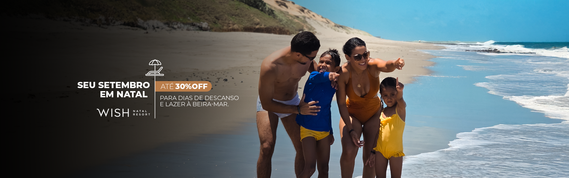 Família de trajes de banho caminhando por uma praia ensolarada ao lado de ondas turquesas e uma faixa de areia.