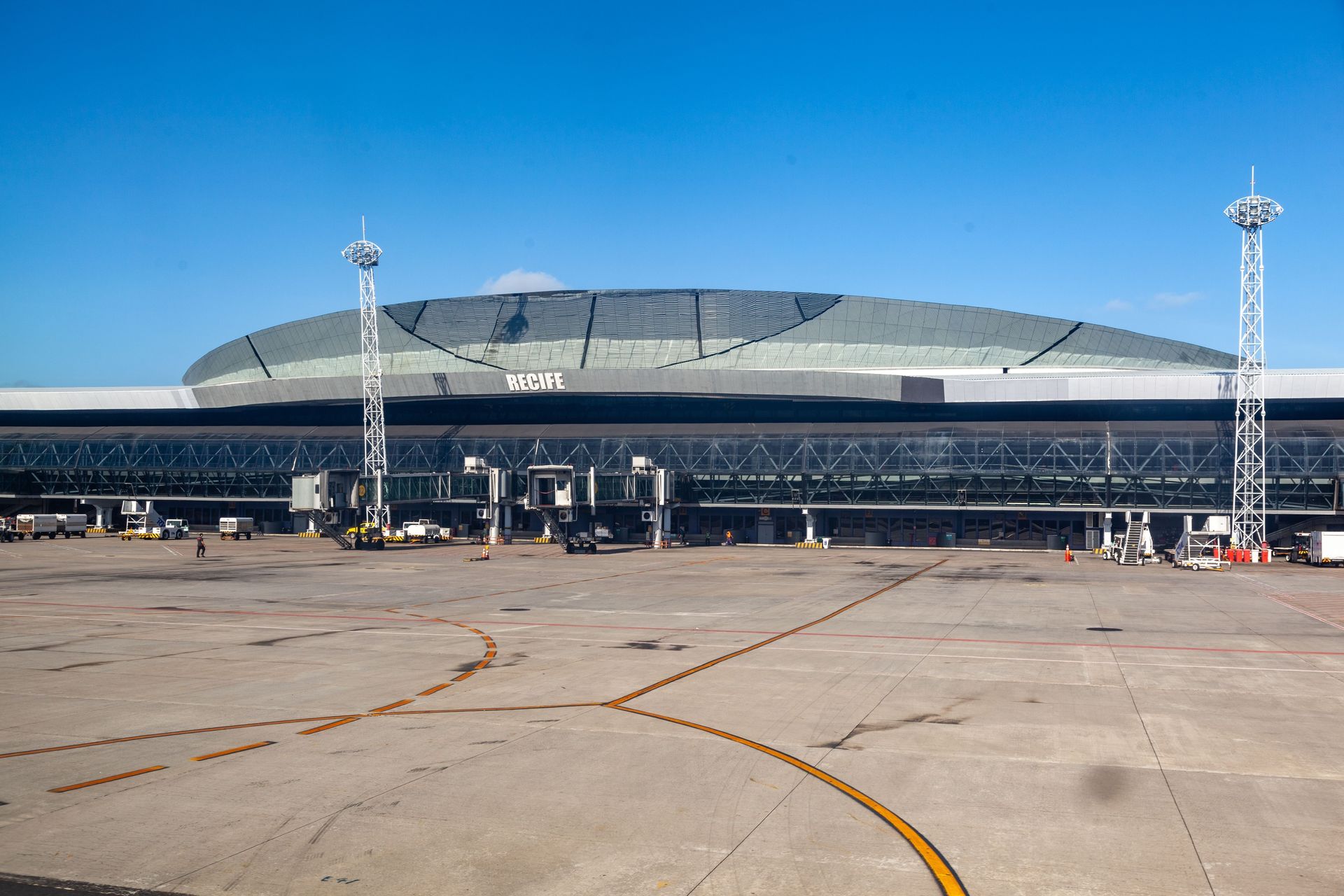 Exterior view of UÇAK airport terminal building under a clear blue sky.
