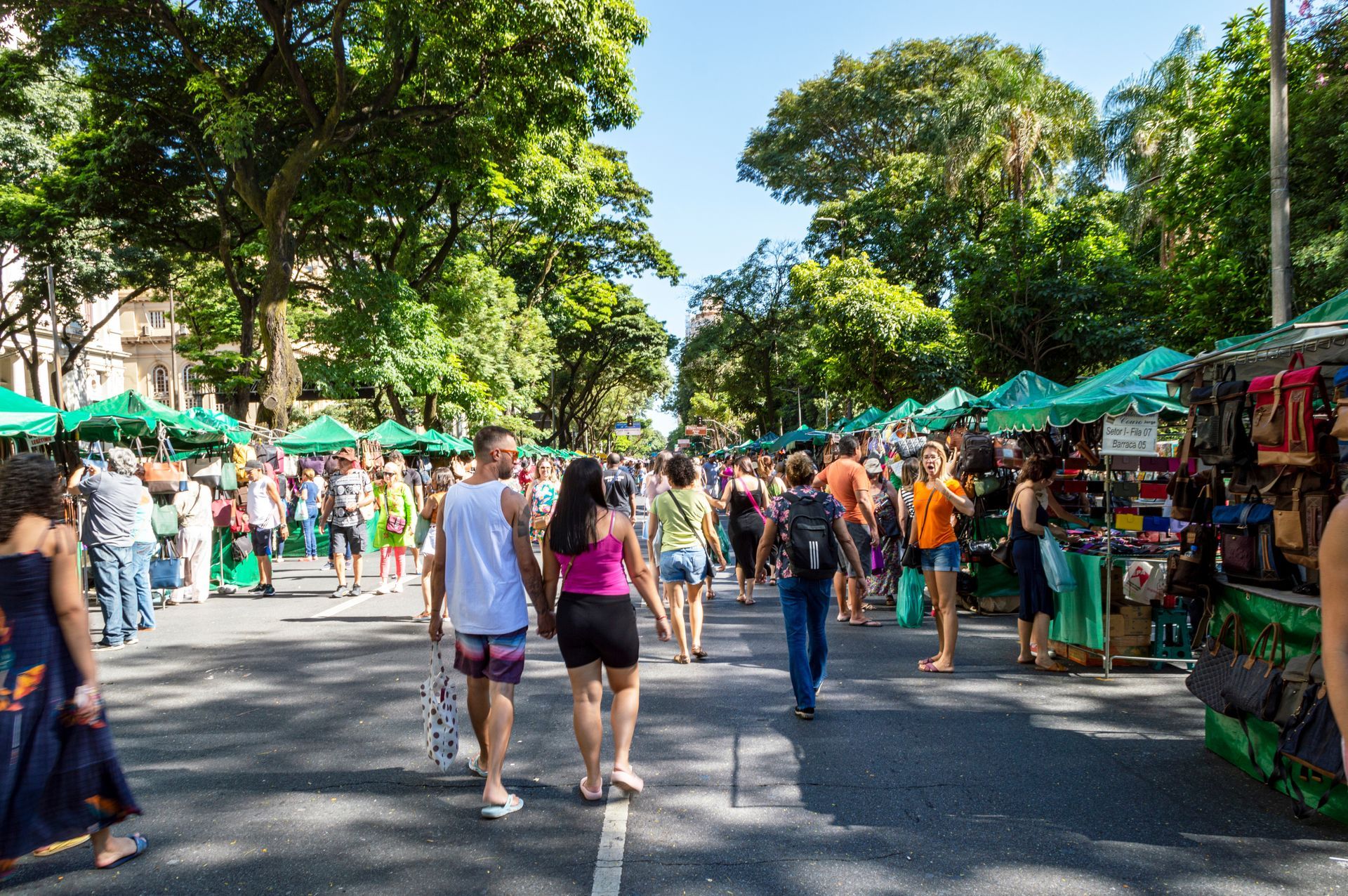 Um grupo de pessoas está caminhando pela rua de um mercado.