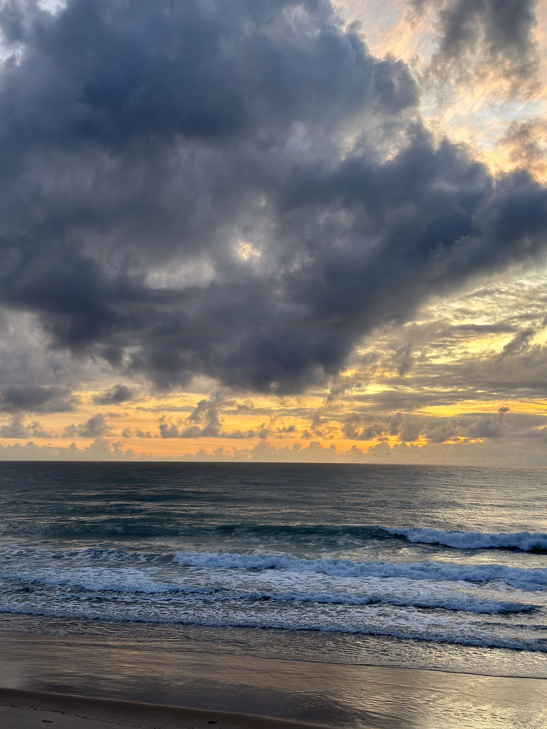 Um pôr do sol sobre o oceano com nuvens no céu