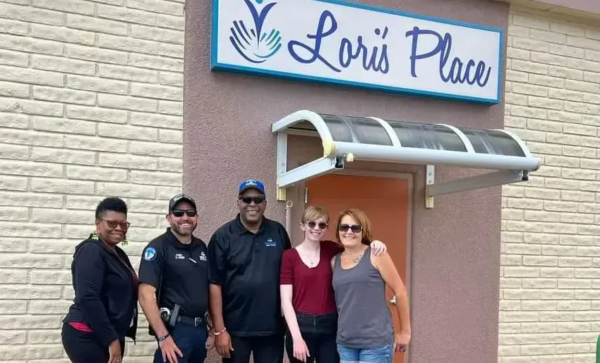 A group of people standing in front of a loris place building.