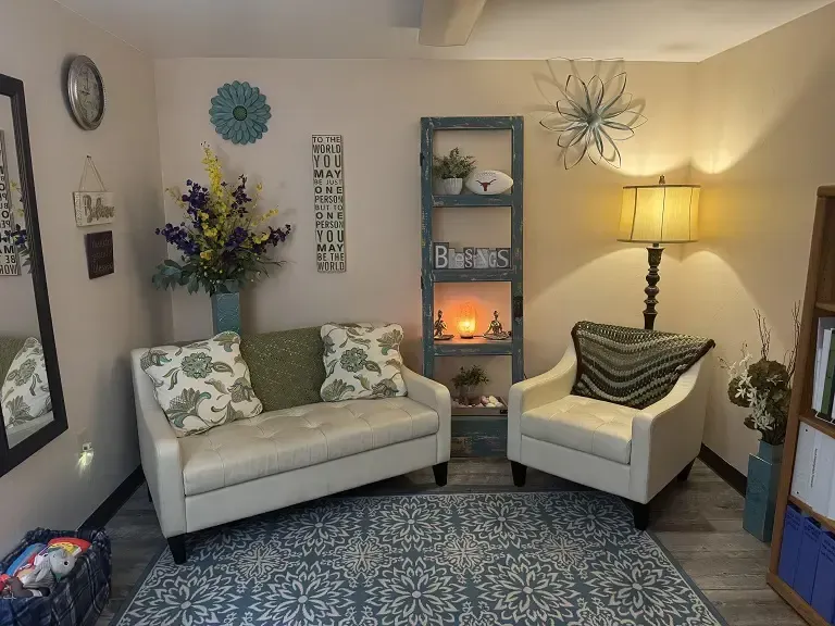 A living room with a couch and two chairs.