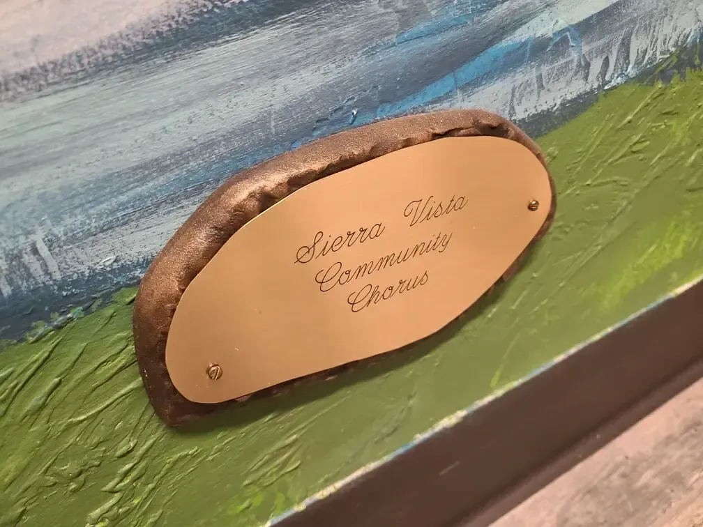 A close up of a plaque on a painting on a wall.
