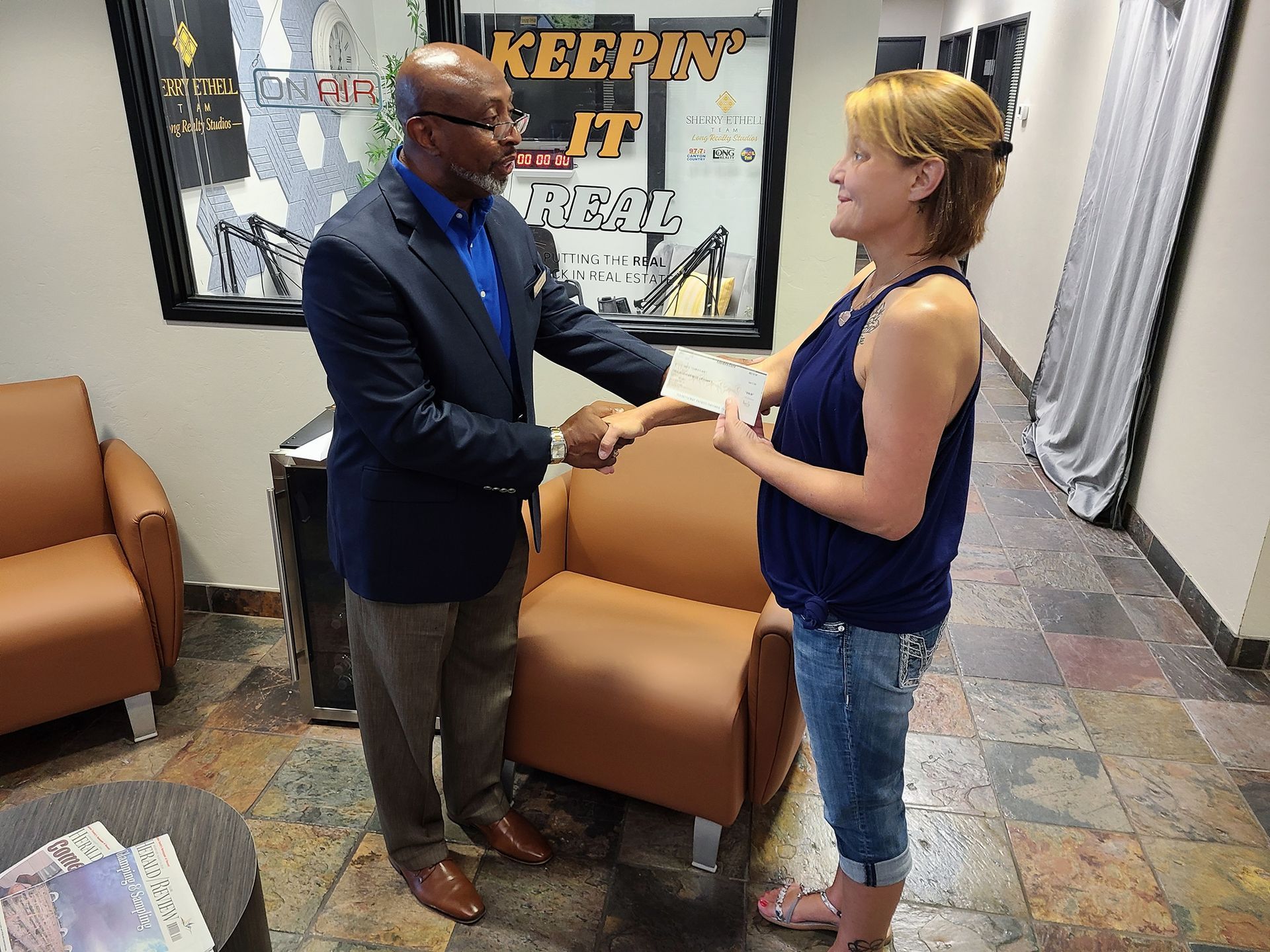A man is shaking hands with a woman in a waiting room.