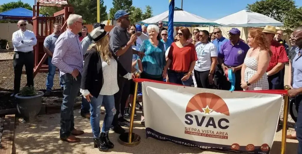 A group of people are standing around a banner that says svac.