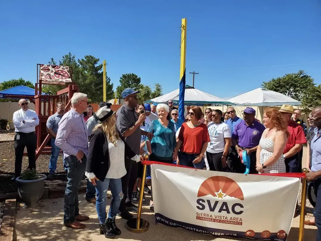 A group of people are standing around a banner that says svac.