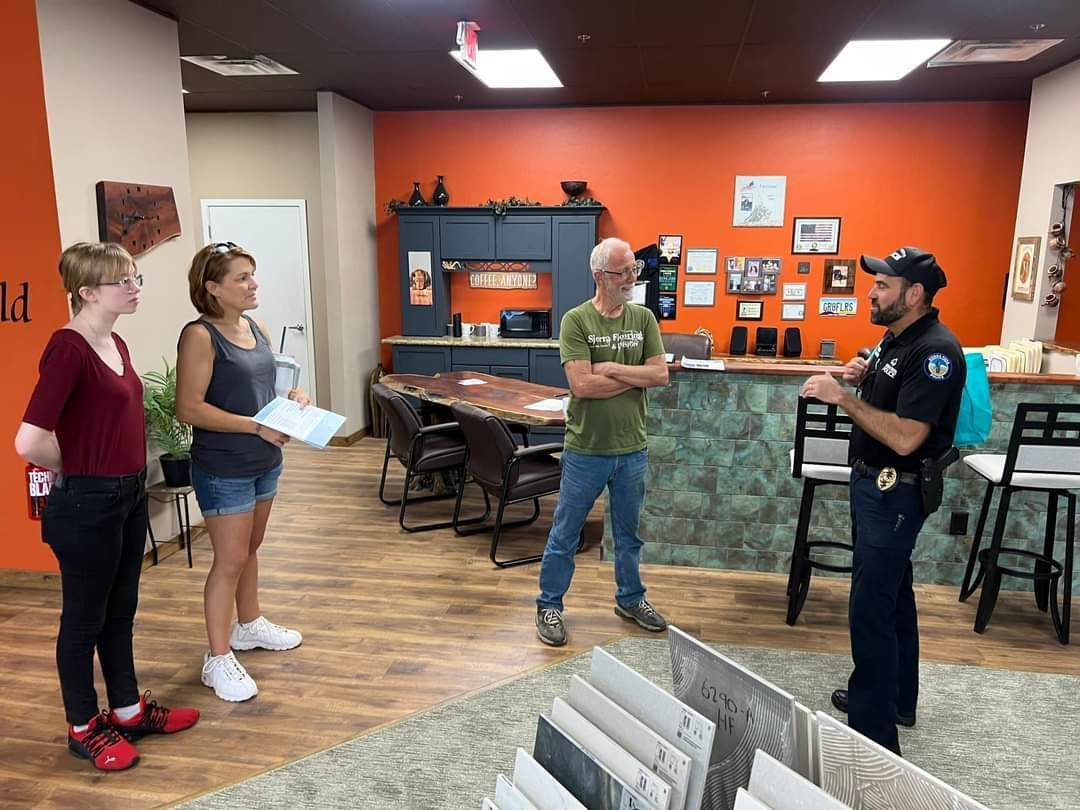 A group of people are standing in a room talking to each other.