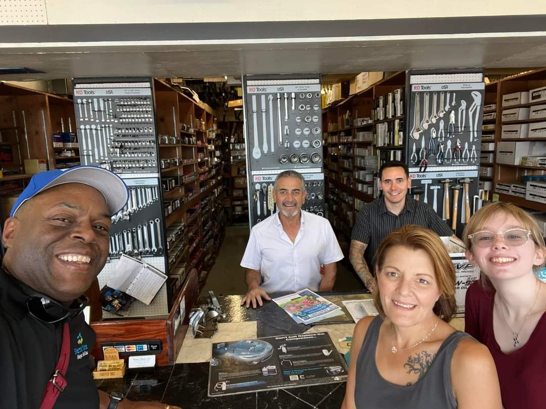 A group of people are posing for a picture in a hardware store.