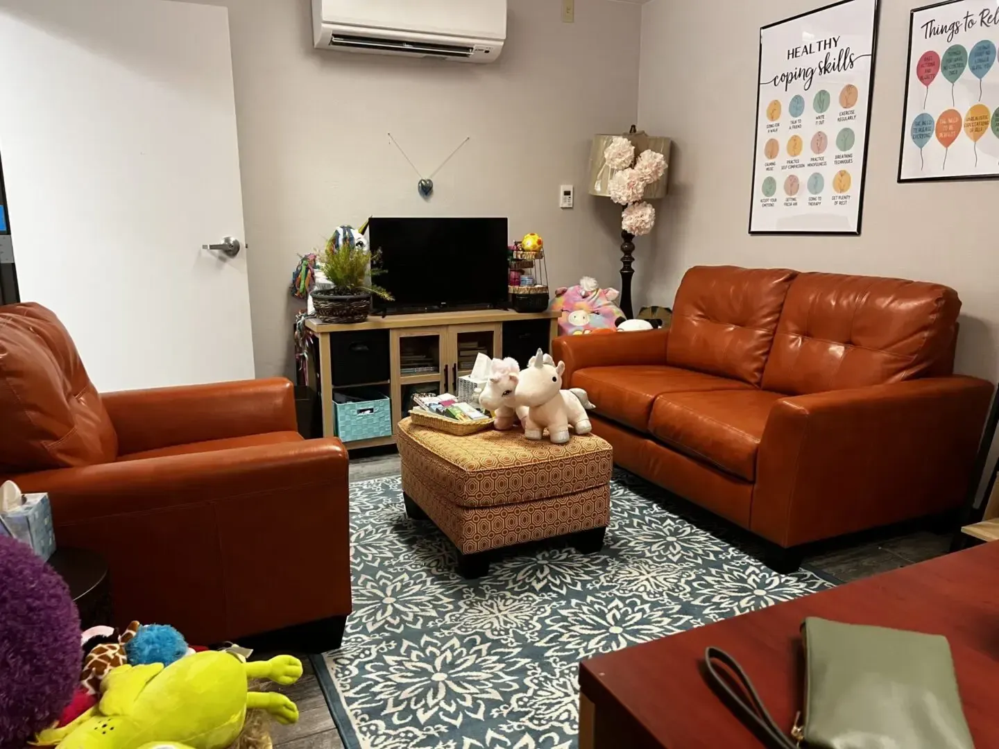 A living room with two couches , two chairs , a coffee table and a television.