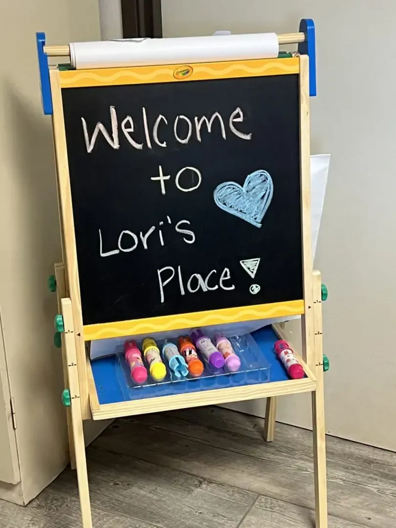 A blackboard with the words welcome to lori 's place written on it