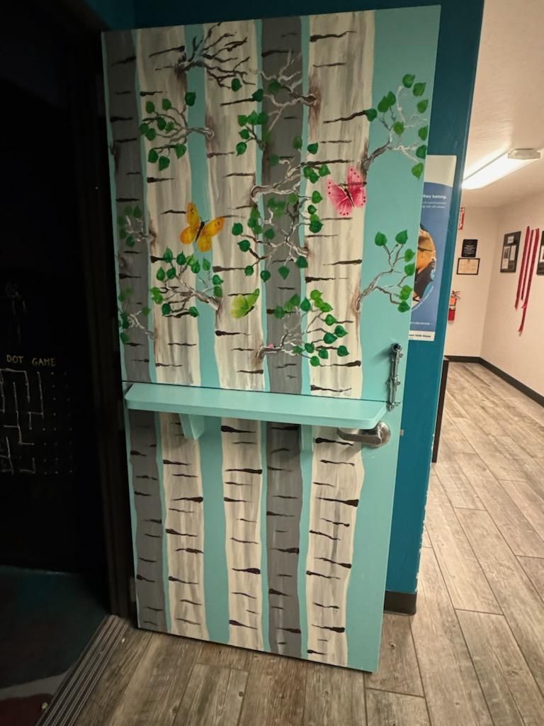 A door with a painting of birch trees on it