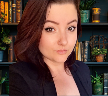 Portrait of a woman in a dark blazer before a bookshelf with books and potted plants