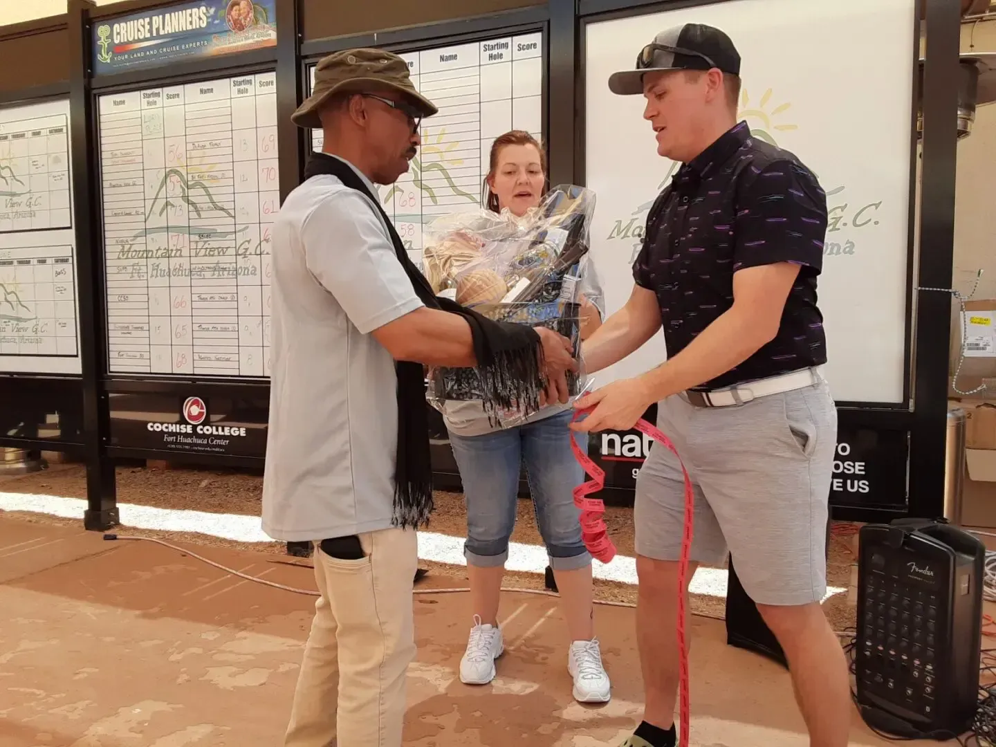 Two men are shaking hands with a woman in front of a white board.