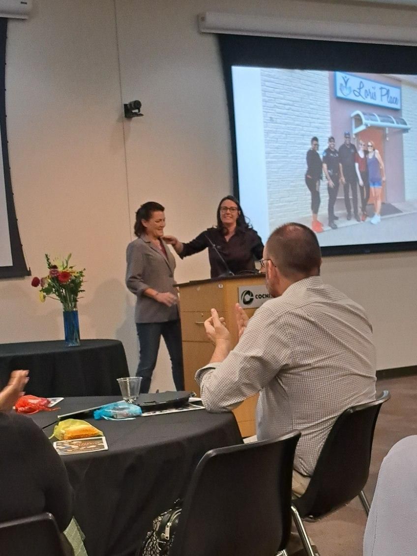 A woman is giving a presentation to a group of people in a room.