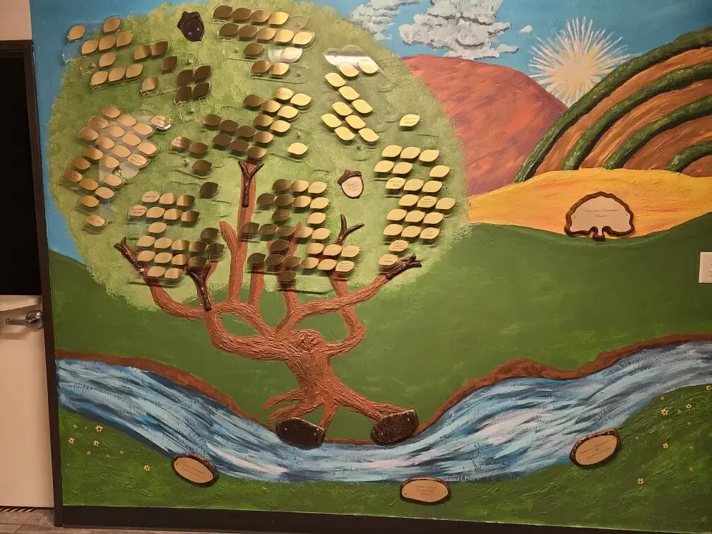 A painting of a tree and a river on a wall