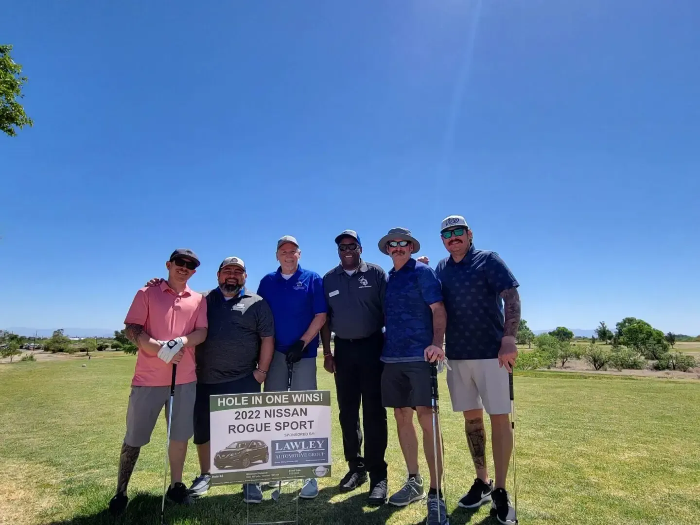 A group of men are posing for a picture on a golf course.
