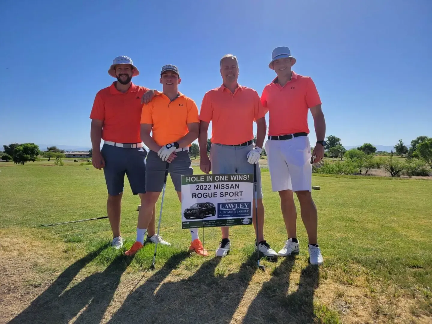 A group of men are posing for a picture on a golf course.