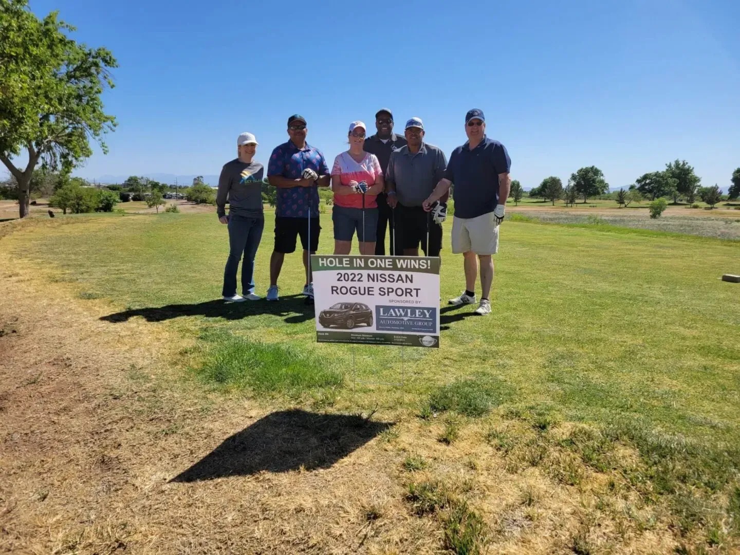 A group of people are posing for a picture on a golf course.