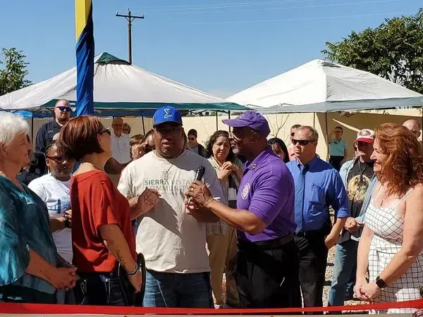 A man in a purple shirt is talking to a group of people