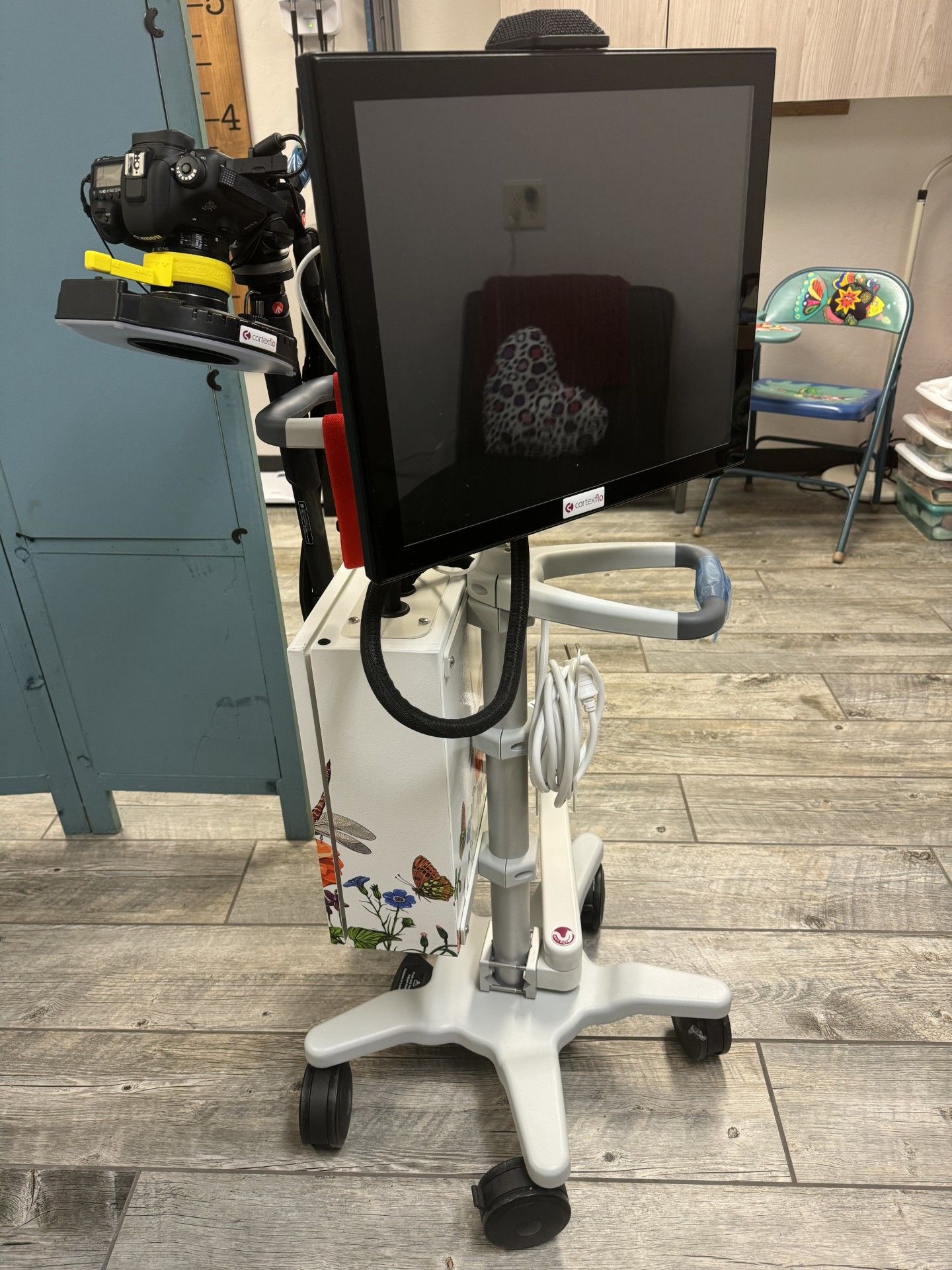A monitor is sitting on top of a cart in a room.