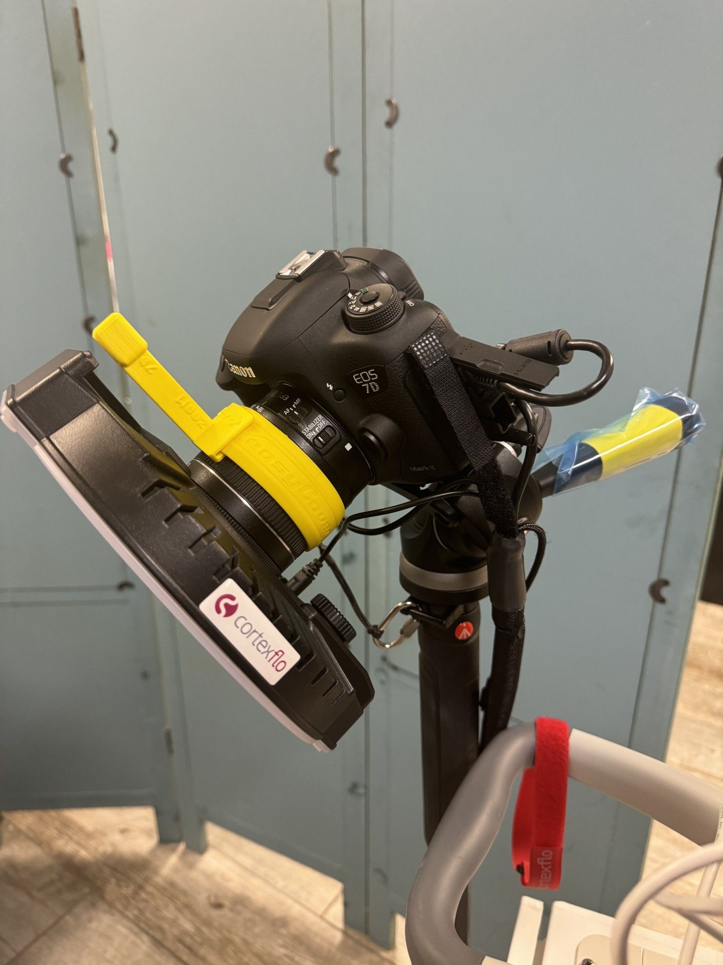 A camera is sitting on top of a tripod with a fan attached to it.