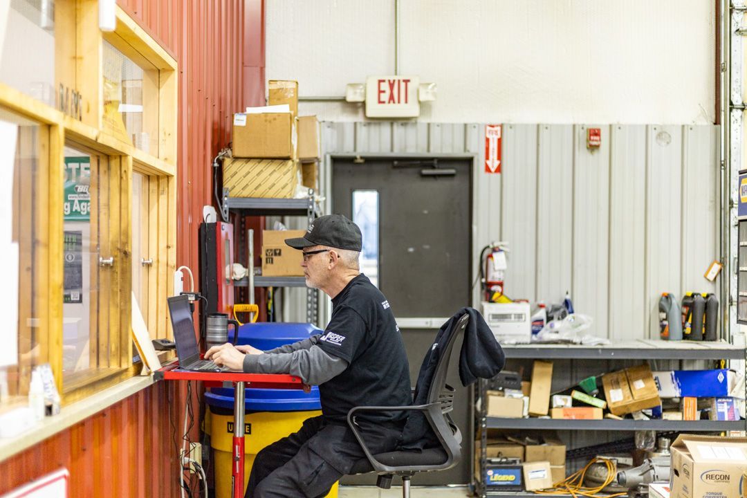 Technician Working on Computer in Shop Office Window | Tex's Transmissions Complete Auto & Truck Care