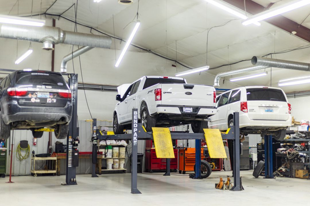 Multiple Vehicles Raised on Lifts Inside Well-Lit Auto Repair Bay | Tex's Transmissions Complete Auto & Truck Care