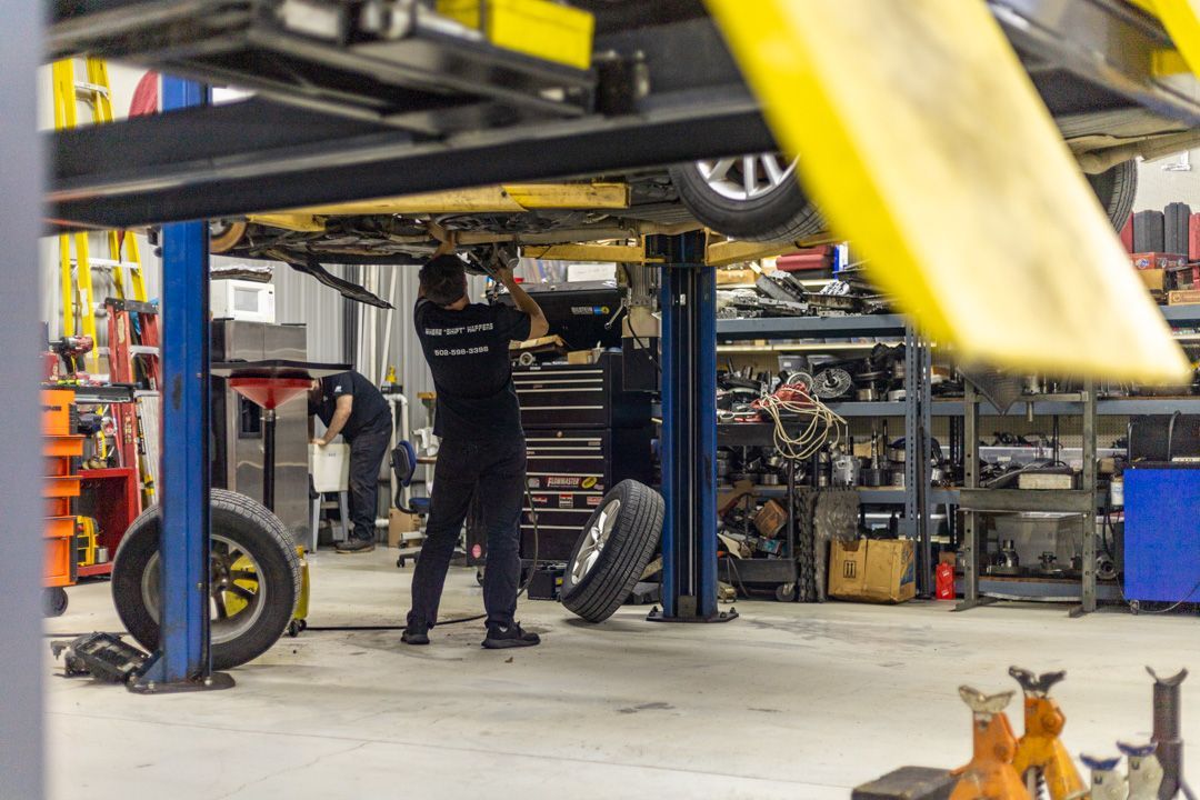 Technician Performing Undercarriage Work on Lifted Vehicle | Tex's Transmissions Complete Auto & Truck Care