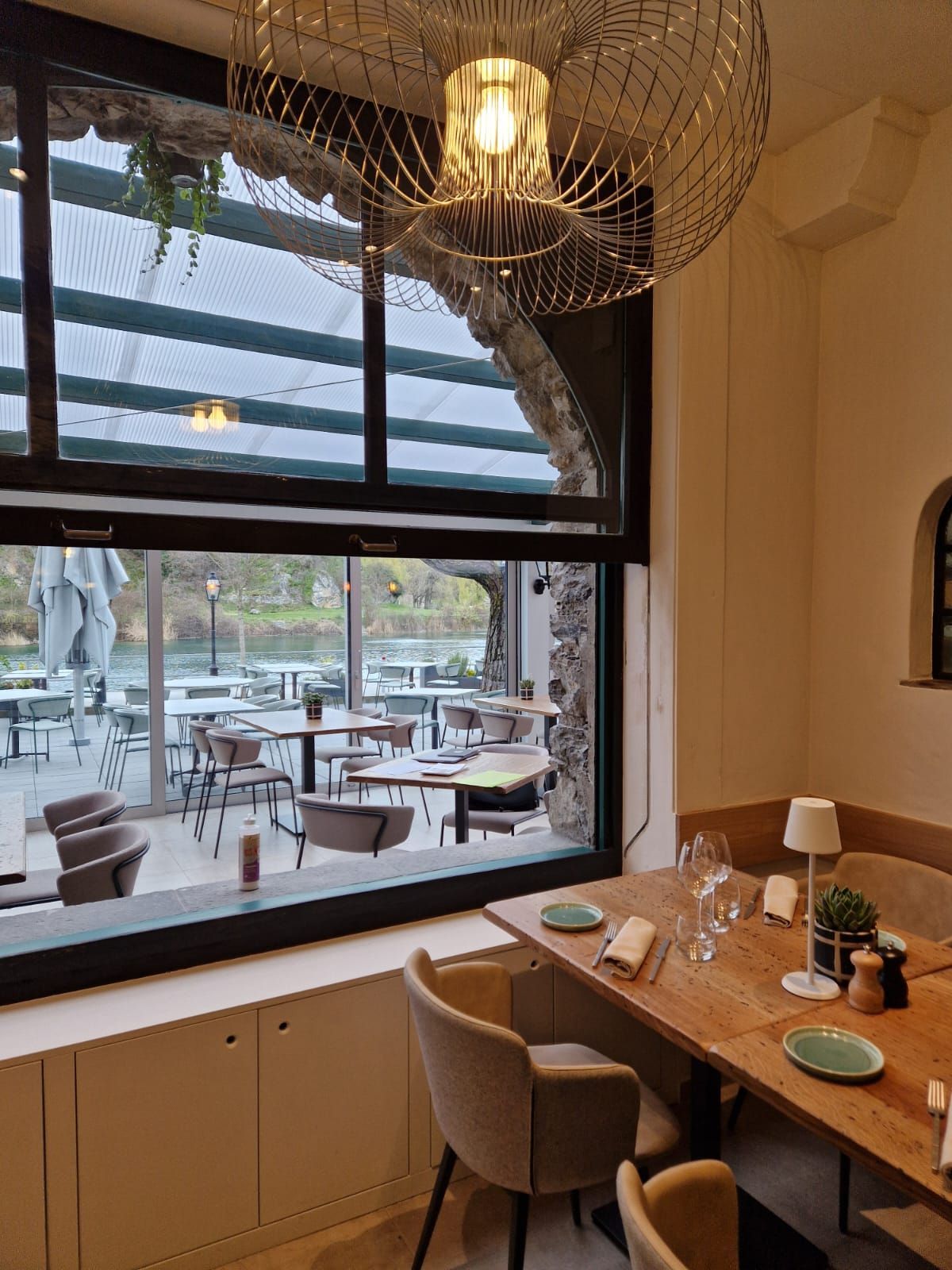 Un restaurant avec tables et chaises et une grande fenêtre.