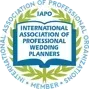 Logo for the International Association of Professional Wedding Planners featuring an open book surrounded by a laurel wreath.