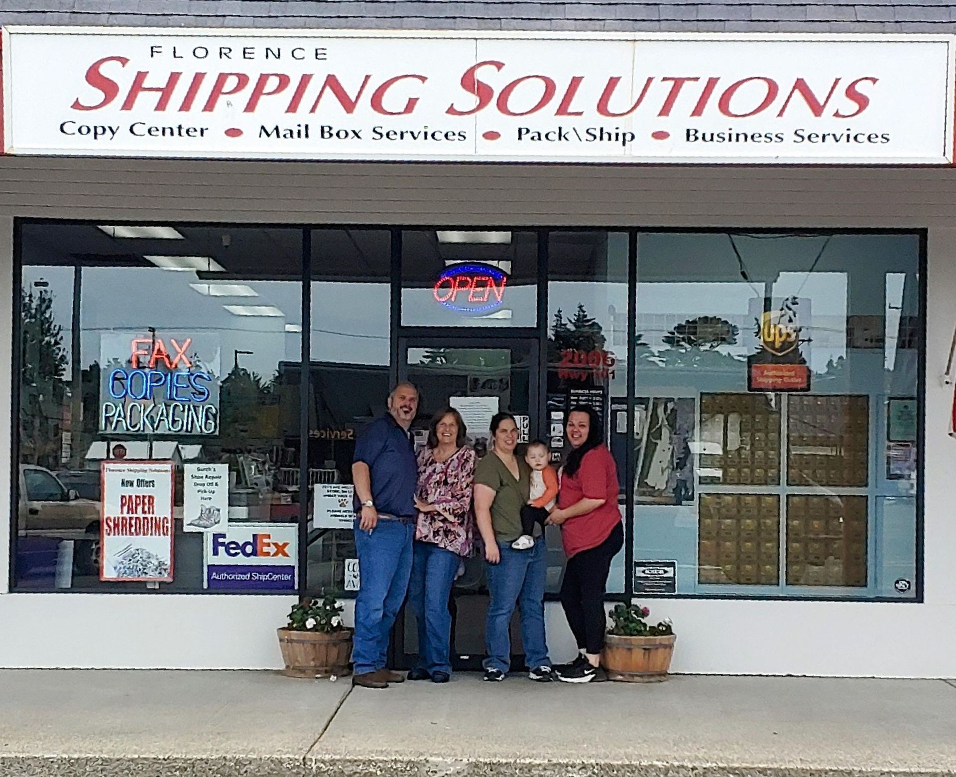A stack of cardboard boxes sitting on top of a wooden table next to a laptop.