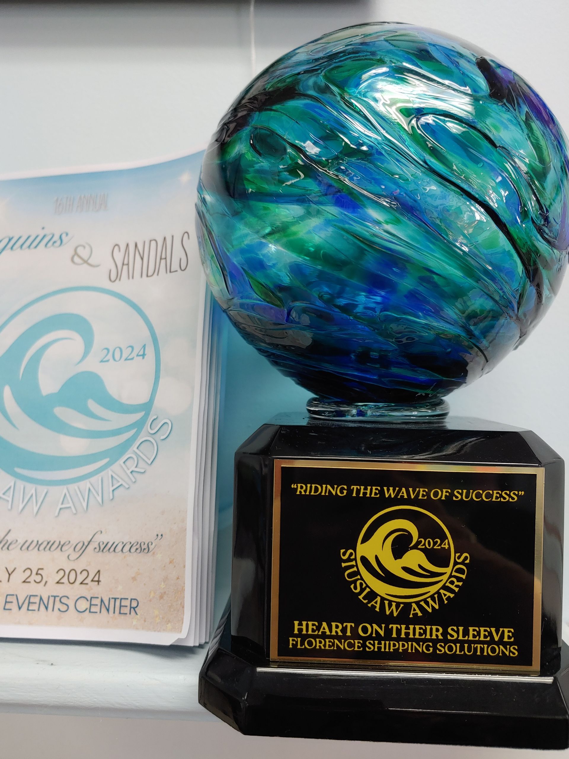 A stack of cardboard boxes sitting on top of a wooden table next to a laptop.