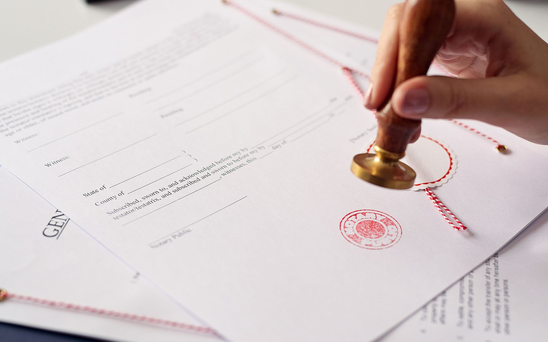 A person is stamping a document with a wax seal.