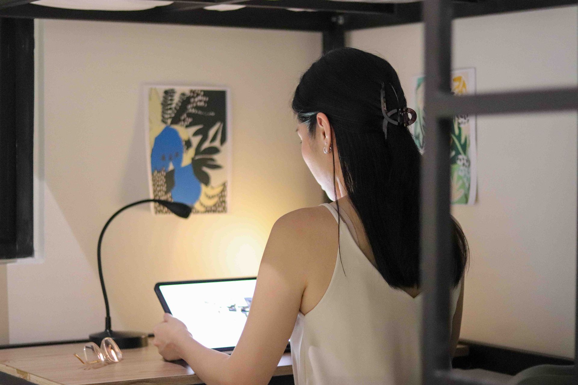 A woman is sitting at a desk using a laptop computer.