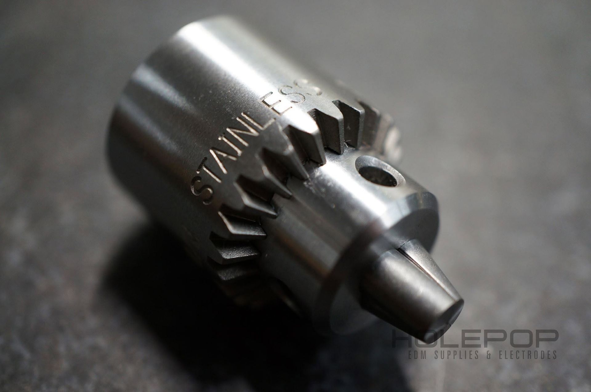 Close-up of a metal gear drill chuck on a dark background