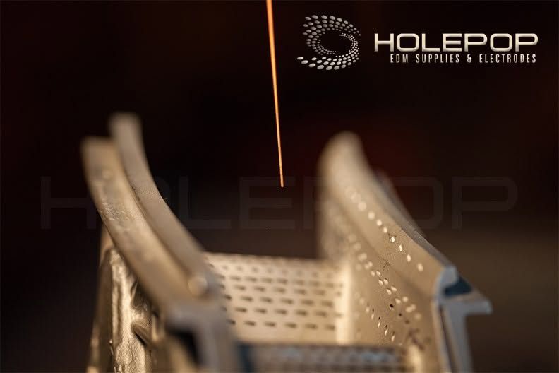 Close-up of a perforated metal chair beside a glowing orange line in a dark setting