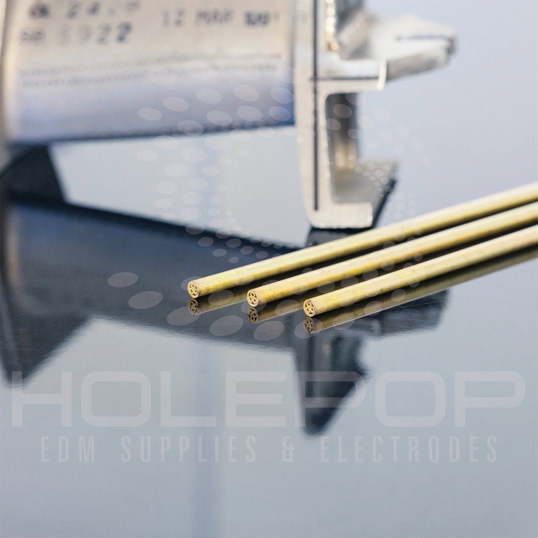 Gold electrodes beside a white dental handpiece on a reflective surface