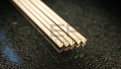 Stack of pale wooden dowels on a dark textured surface