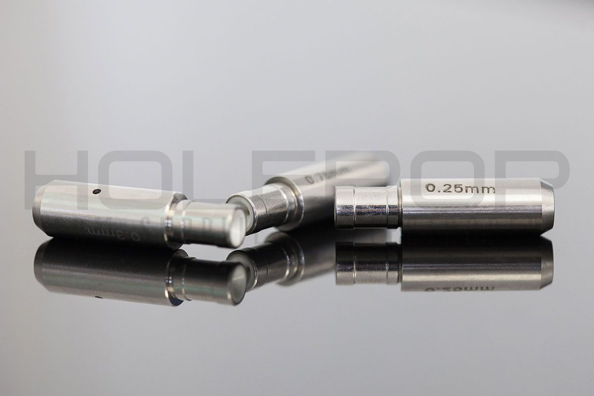 Two shiny silver metal tool bits resting side by side on a reflective surface