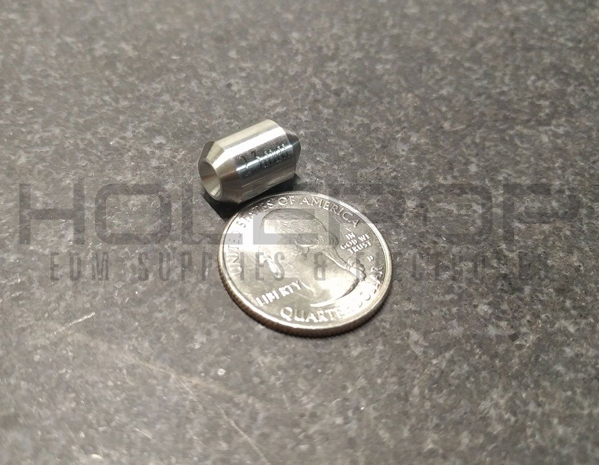 Small metallic cylinder resting beside a quarter on a gray countertop.