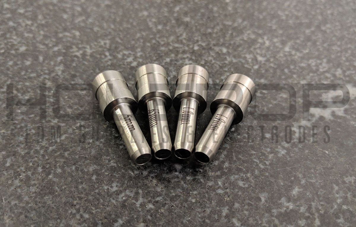 Four small metal sockets with black ends arranged in a fan on a speckled countertop