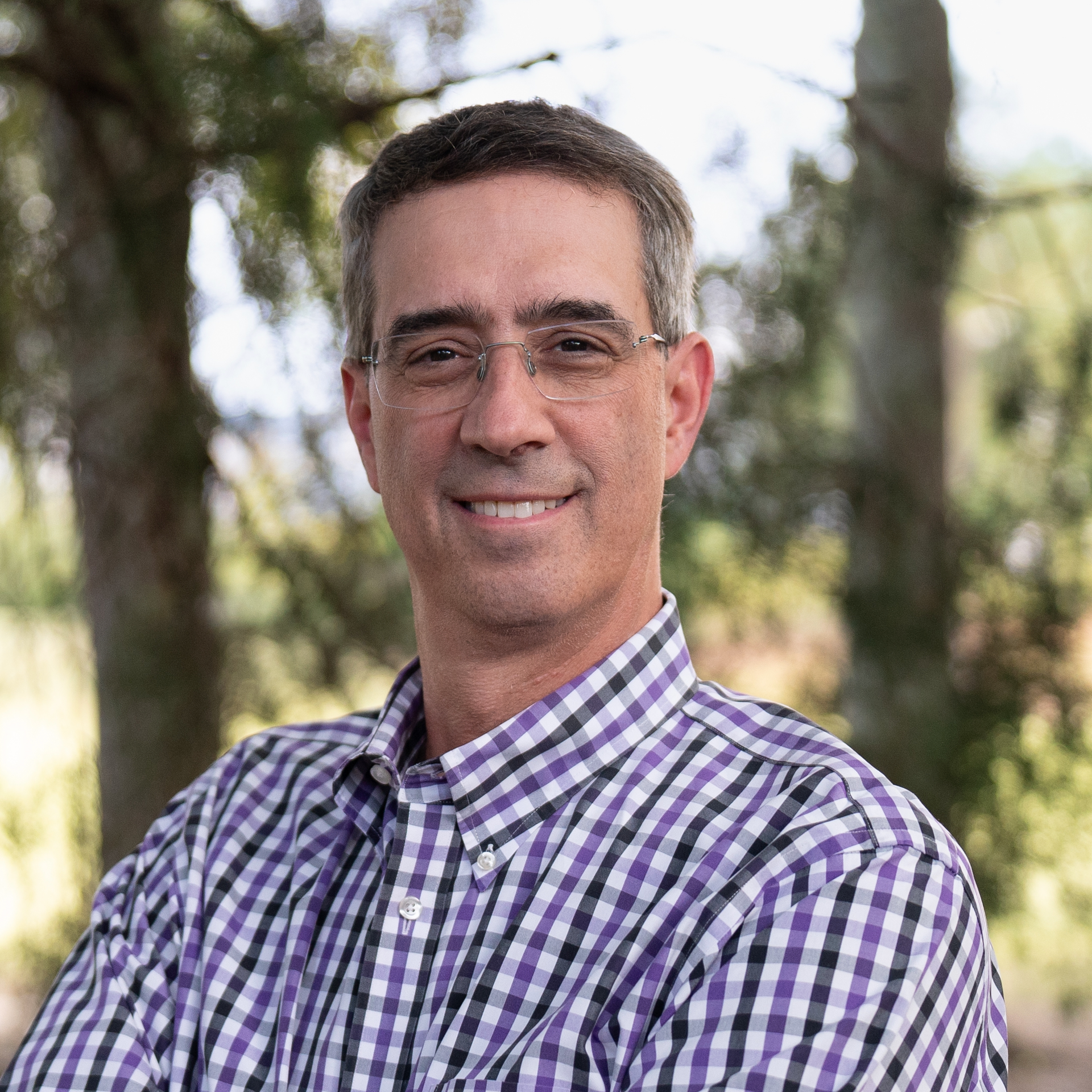 A man with a beard and glasses is wearing a suit and vest.