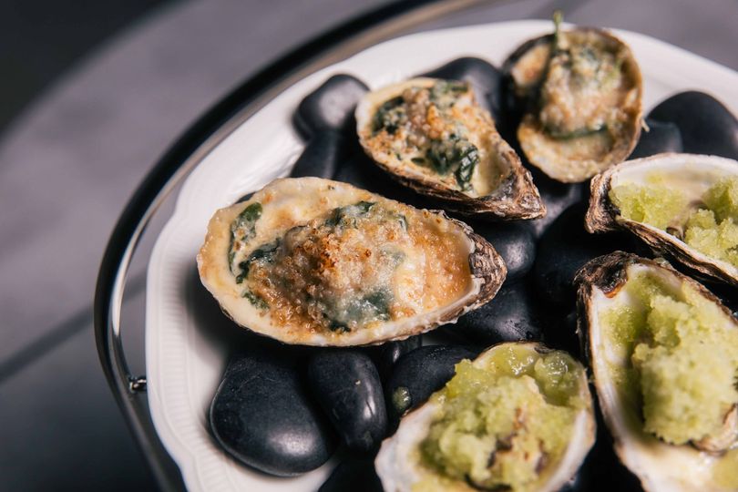 Un serveur porte deux assiettes de nourriture dans un restaurant.